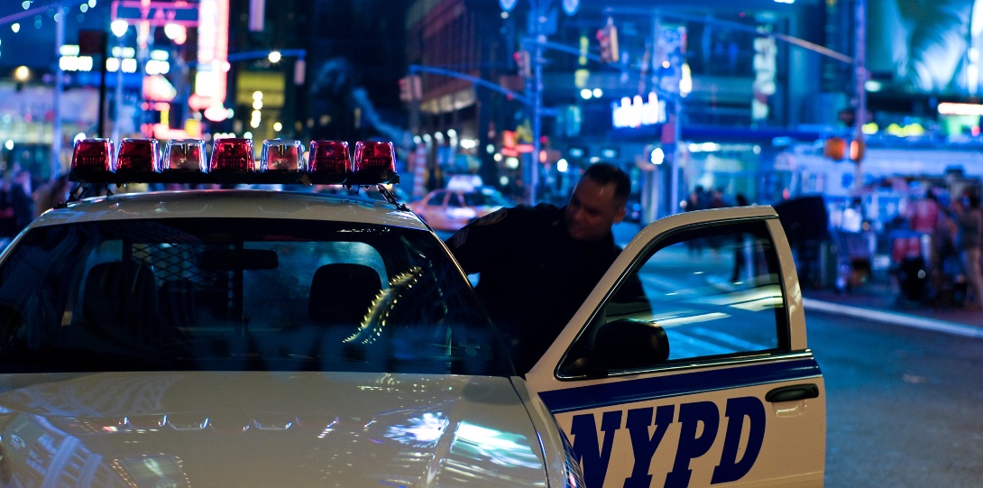 A police officer enters a squad car parked near Times Square in New York City.